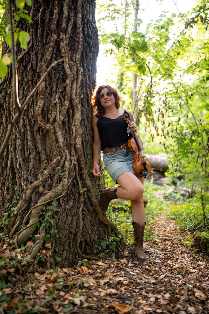 Ari von Free Range Chicks mit Geige an einem Baum